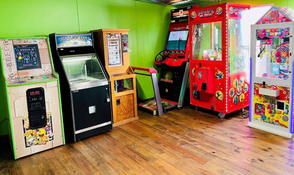 Colorful arcade game machines in a vibrant room with wooden flooring, perfect for family fun and entertainment.
